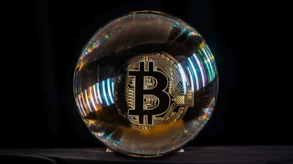 Glaskugel mit Bitcoin Münze im Inneren