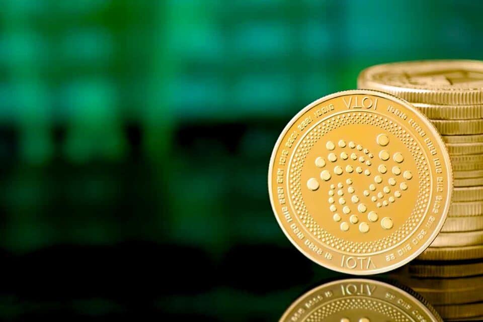 Goldene IOTA Münze auf grünem Hintergrund