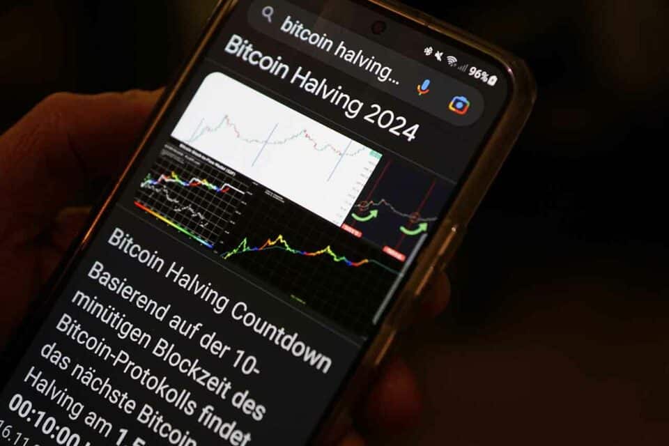 Smartphone mit Grafiken und Charts zum Bitcoin Halving 2024