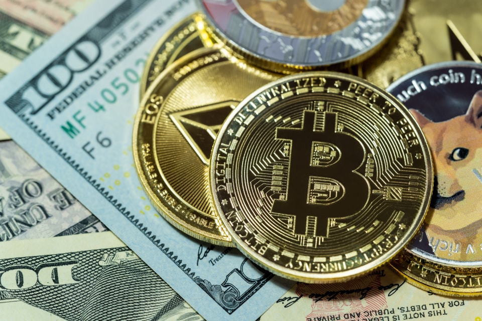 Bitcoin und andere Krypto-Münzen liegen auf Dollarnoten
